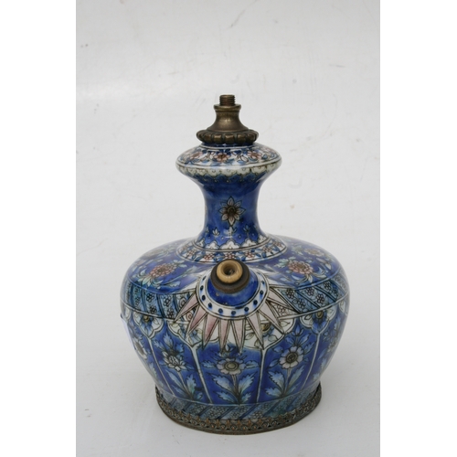 320 - A Persian pottery hookah base decorated with flowers on a blue ground, 21cms (8.25ins) high.