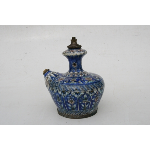 320 - A Persian pottery hookah base decorated with flowers on a blue ground, 21cms (8.25ins) high.