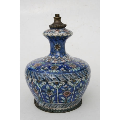 320 - A Persian pottery hookah base decorated with flowers on a blue ground, 21cms (8.25ins) high.