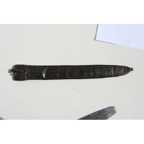 233 - A Congolese Yaka long knife having a shaped leather hilt with wire cage to the centre and a flat iro... 