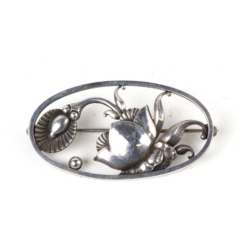 1004 - A Georg Jensen oval silver brooch decorated with stylised flowers, number '274', 4cms (1.5ins) wide.