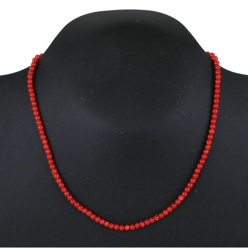 1014 - A coral bead necklace with 18ct gold clasp, 42cm (16.5 ins) long.