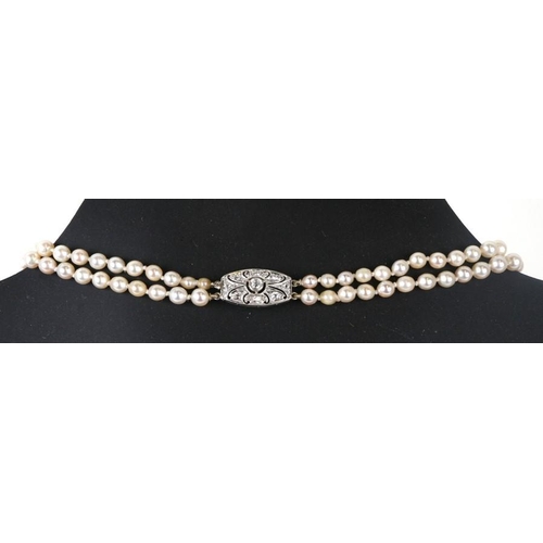 228 - A double strand pearl necklace with diamond set white metal clasp.39cm (15.25 ins) long