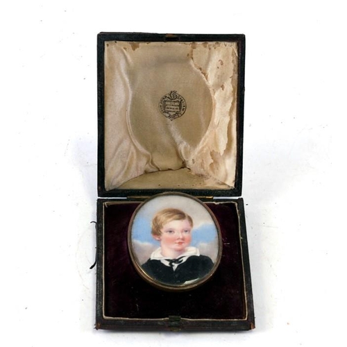 235 - A portrait miniature depicting a young boy, mounted as a brooch in its original shaped and fitted bo... 