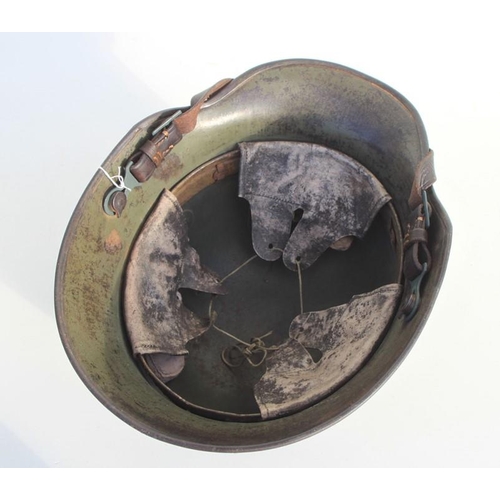 352 - A Third Reich M1916 double decal German helmet with traces of green camoflage paint, with liner and ... 