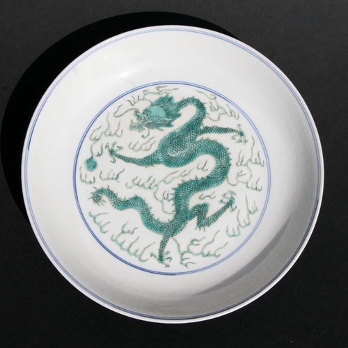 387 - A Chinese famille vert shallow dish decorated with dragons chasing a flaming pearl, blue seal mark t... 