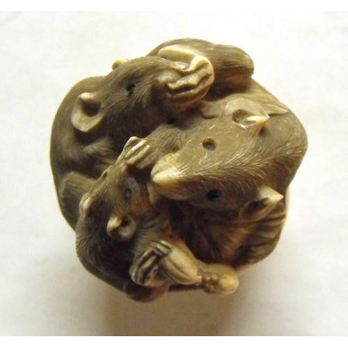 397 - A signed Japanese ivory cane handle carved as a family of entwined rats, 4.5cms (1.75ins) diameter.