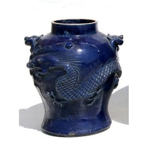 406 - A Chinese blue glazed pottery vase decorated in relief with a scrolling dragon and with lion mask ha... 