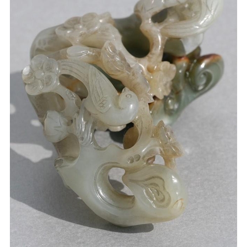 454 - A Chinese jade carving depicting birds amongst flowering foliage, 9cms (3.5ins) long.