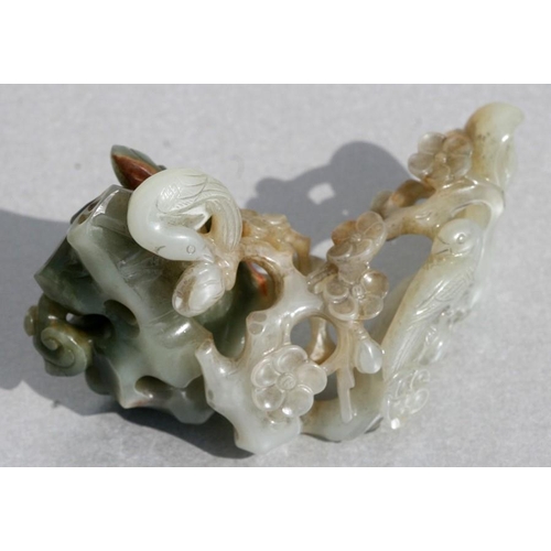 454 - A Chinese jade carving depicting birds amongst flowering foliage, 9cms (3.5ins) long.