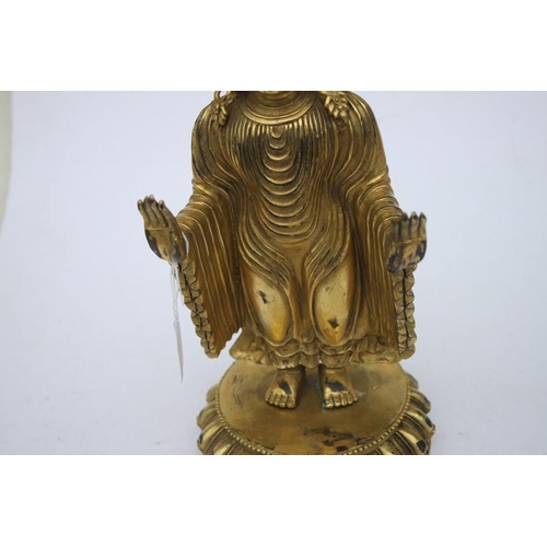 490 - A Chinese gilded bronze standing robed Buddha figure, 33cms (13ins) high.