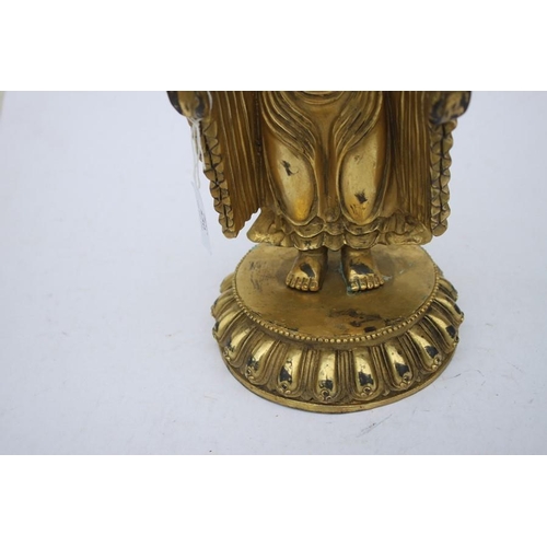 490 - A Chinese gilded bronze standing robed Buddha figure, 33cms (13ins) high.