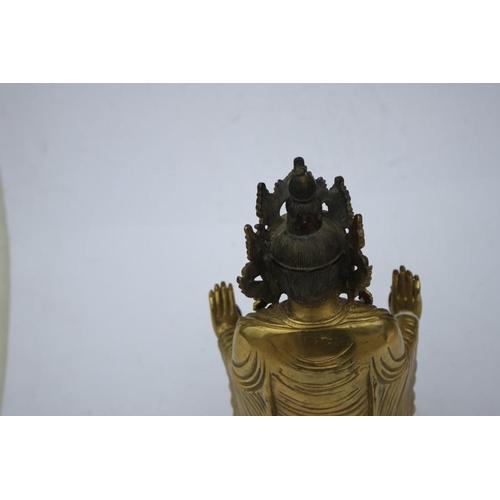 490 - A Chinese gilded bronze standing robed Buddha figure, 33cms (13ins) high.