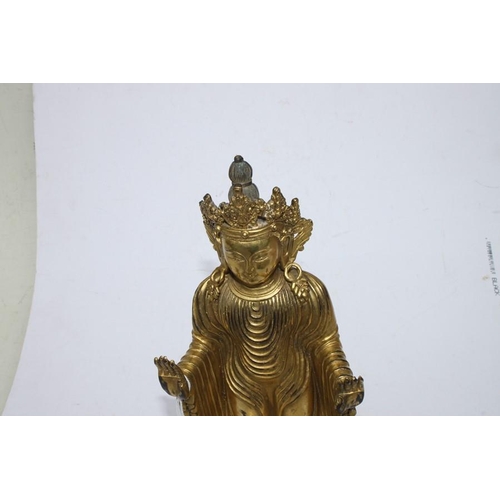 490 - A Chinese gilded bronze standing robed Buddha figure, 33cms (13ins) high.