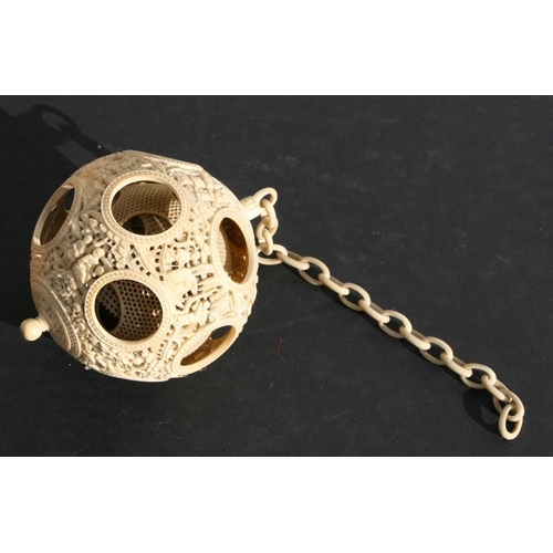 502 - A 19th century Chinese ivory hanging puzzle ball decorated with figures in a landscape, 10cms 94ins)... 