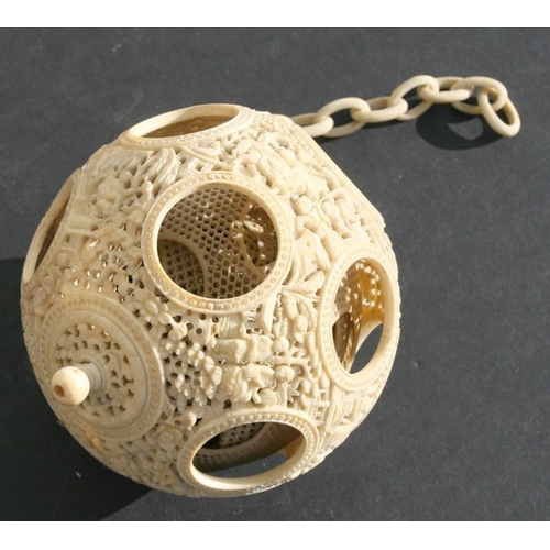 502 - A 19th century Chinese ivory hanging puzzle ball decorated with figures in a landscape, 10cms 94ins)... 