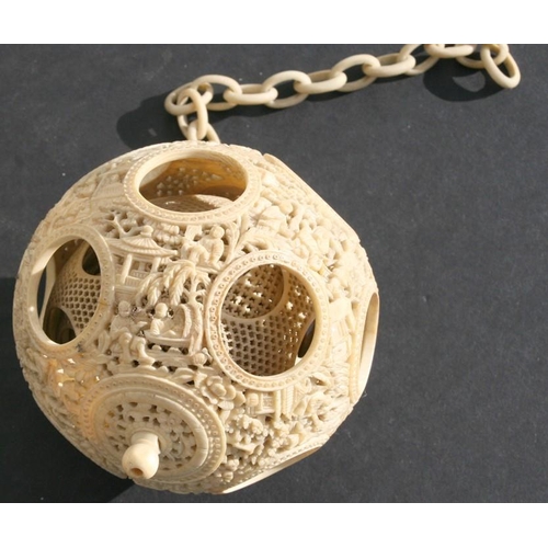 502 - A 19th century Chinese ivory hanging puzzle ball decorated with figures in a landscape, 10cms 94ins)... 