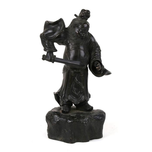 542 - A Japanese bronze figure in the form of a warrior holding a sword, on a rocky base, 33cms (13ins) hi... 