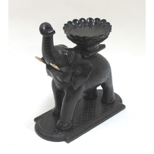 552 - A large Burmese bowl stand carved in the form of an elephant. 36cm ( 14 ins) high