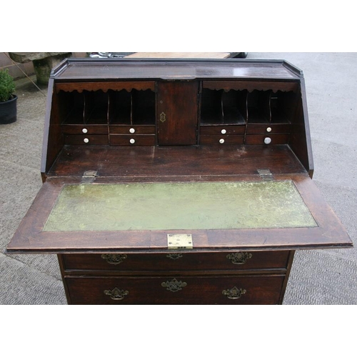 783 - A Georgian oak bureau, the fall front enclosing a fitted interior above four long graduated drawers,... 