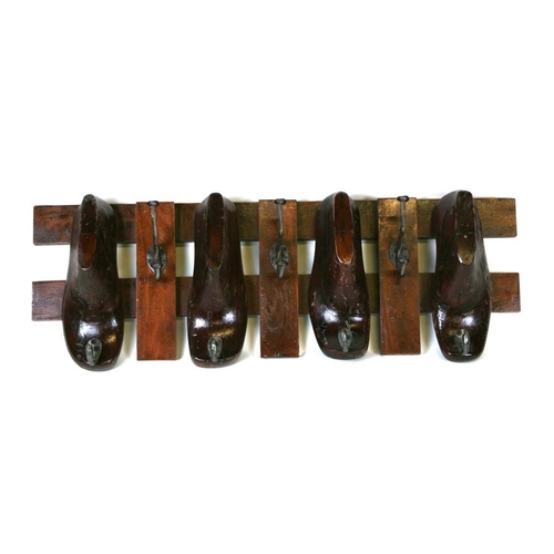 792 - A set of seven coat hooks mounted on a wooden frame with four shoe lasts, 77cms (13.5ins) wide.