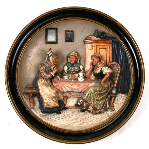 809 - A 19th century German painted terracotta wall plaque depicting old women having tea, impressed 'Must... 