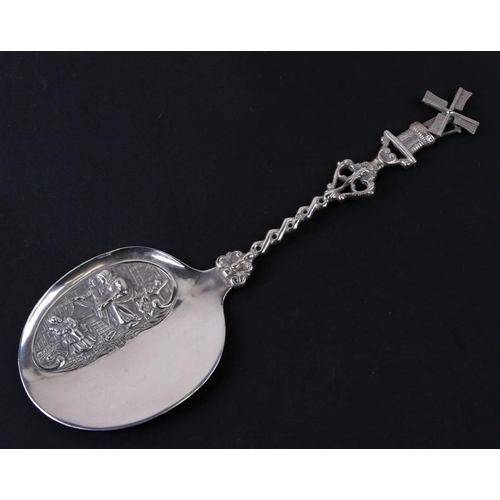 959 - A Dutch silver serving slice with embossed scene and an ornate handle with windmill terminal, 23cms ... 