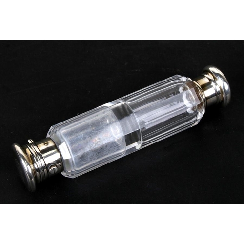 975 - A Victorian clear glass double ended scent bottle with unmarked silver mounts. 13cm (5 ins) long