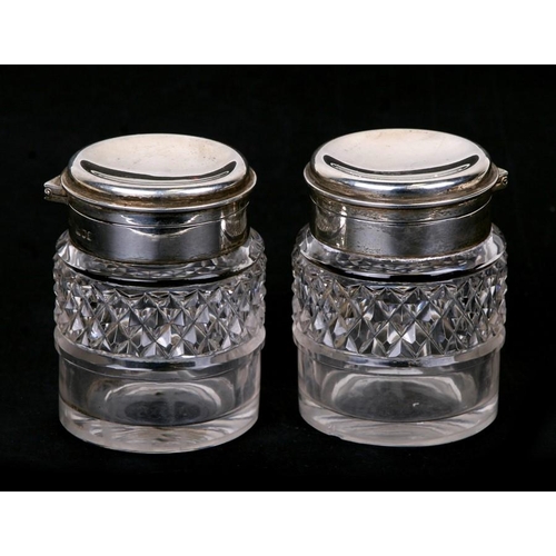 976 - A pair of large Victorian silver lidded cut glass inkwell bottles. London 1896.