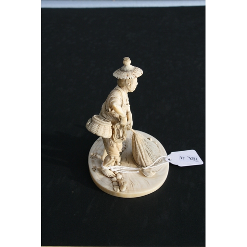 426 - A 19th century Japanese carved ivory okimono in the form of a fisherman with his net and creel on hi... 