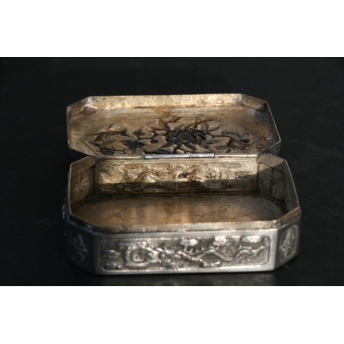 543 - A Chinese silver snuff box of shaped rectangular form with embossed bird, flower and dragon decorati... 