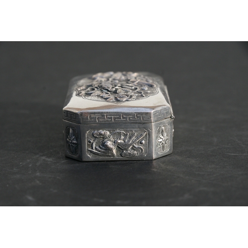 543 - A Chinese silver snuff box of shaped rectangular form with embossed bird, flower and dragon decorati... 