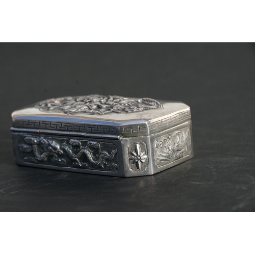 543 - A Chinese silver snuff box of shaped rectangular form with embossed bird, flower and dragon decorati... 