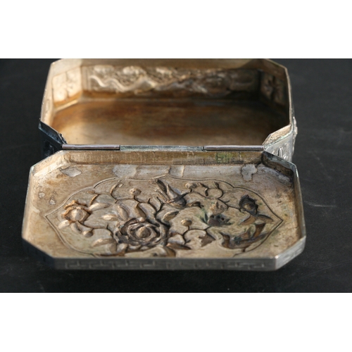 543 - A Chinese silver snuff box of shaped rectangular form with embossed bird, flower and dragon decorati... 