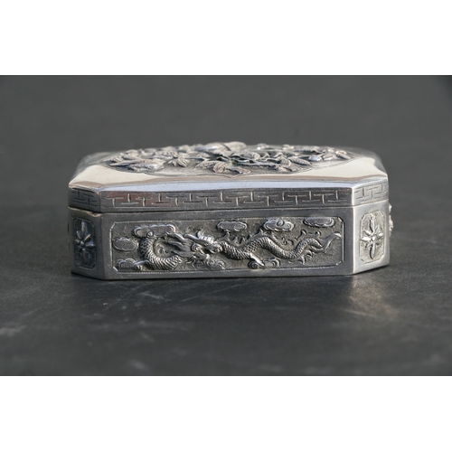 543 - A Chinese silver snuff box of shaped rectangular form with embossed bird, flower and dragon decorati... 