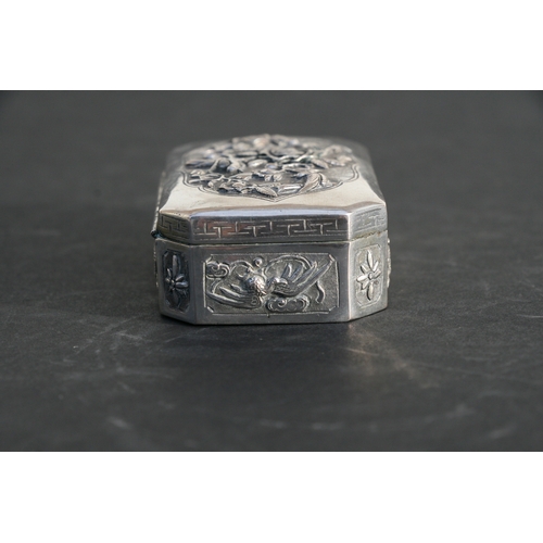 543 - A Chinese silver snuff box of shaped rectangular form with embossed bird, flower and dragon decorati... 