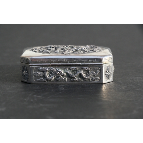 543 - A Chinese silver snuff box of shaped rectangular form with embossed bird, flower and dragon decorati... 