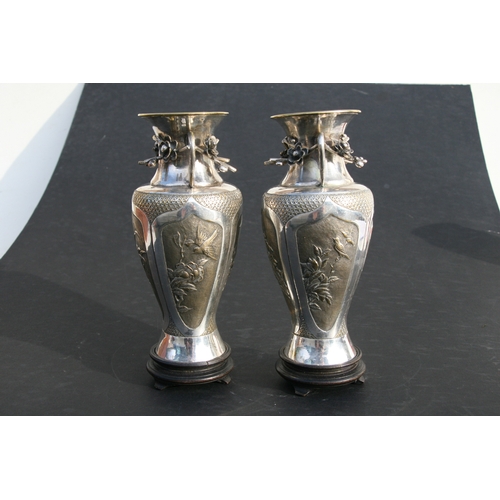 545 - A pair of Chinese silver plated vases of baluster form, embossed birds, bamboo, flowers and a vacant... 