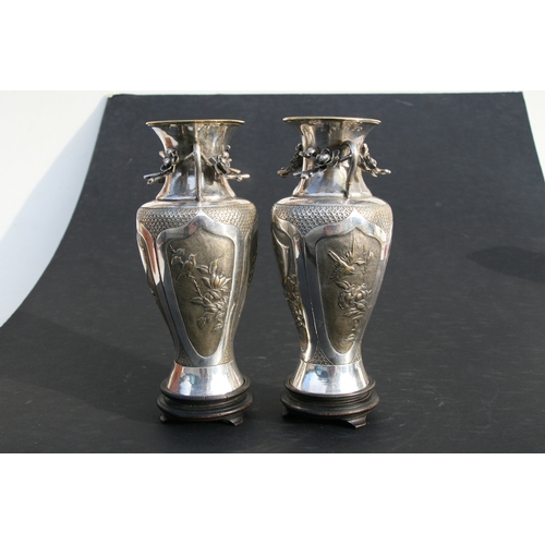 545 - A pair of Chinese silver plated vases of baluster form, embossed birds, bamboo, flowers and a vacant... 