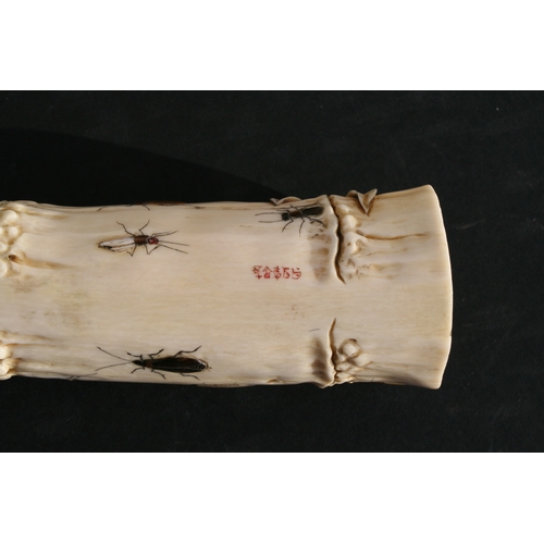 539 - An Oriental carved ivory wrist stand in the form of a bamboo section with shibayama insect decoratio... 