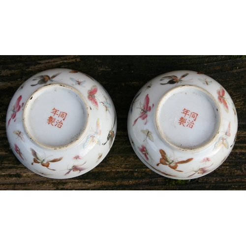 524 - A pair of Chinese porcelain wine cups decorated with butterflies, four character red mark to the und... 