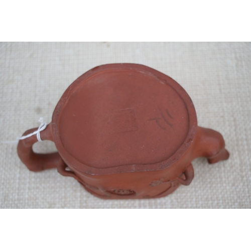 403 - A Chinese Yixing pottery teapot decorated with prunus, impressed seal mark to the underside, 9cm (3.... 