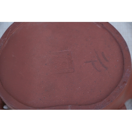 403 - A Chinese Yixing pottery teapot decorated with prunus, impressed seal mark to the underside, 9cm (3.... 