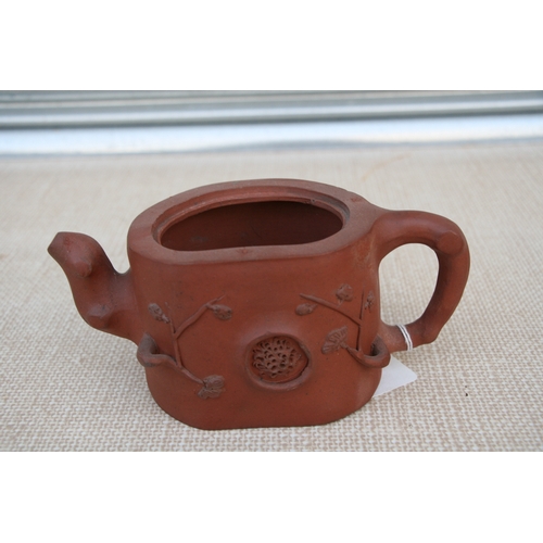 403 - A Chinese Yixing pottery teapot decorated with prunus, impressed seal mark to the underside, 9cm (3.... 