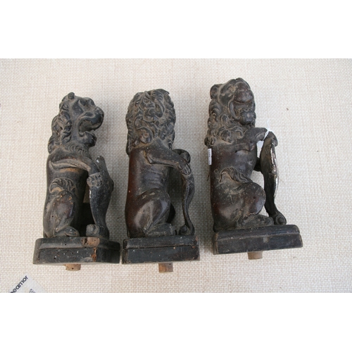 611 - Three late 18th century carved oak rampant lions holding shields, each approx 23cms (9ins) high (3).