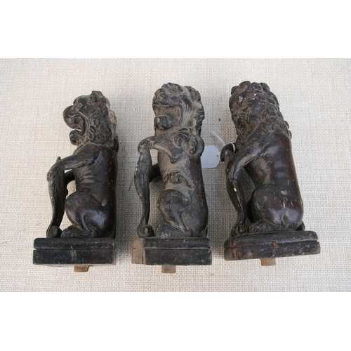 611 - Three late 18th century carved oak rampant lions holding shields, each approx 23cms (9ins) high (3).