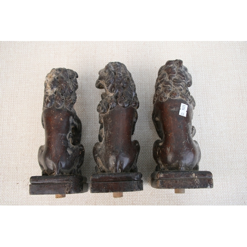 611 - Three late 18th century carved oak rampant lions holding shields, each approx 23cms (9ins) high (3).