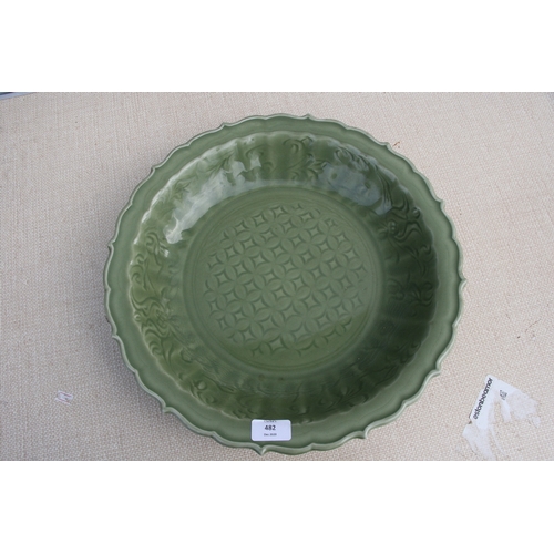 482 - A large Chinese celadon glaze shallow bowl with incised decoration, 40cms (15.75ins) diameter.