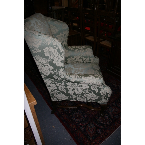 767 - An 18th century style upholstered wing back armchair on shell capped dwarf cabriole legs, with pad f... 