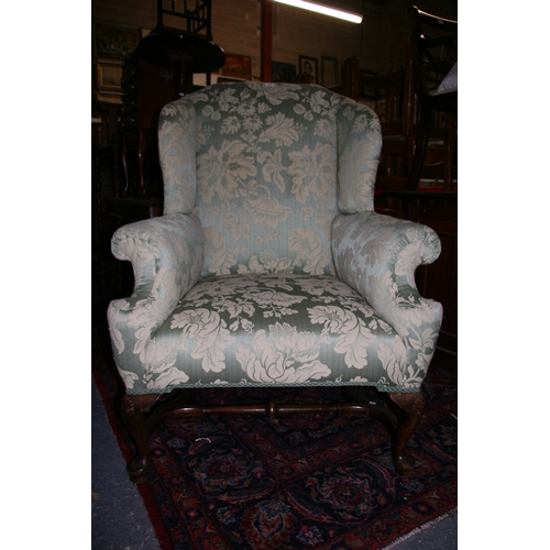 767 - An 18th century style upholstered wing back armchair on shell capped dwarf cabriole legs, with pad f... 